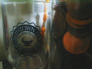 Pennies and Nickels in the Elizabethtown College Hershey Foods Honors Mug. Yes. Logo by J. Nathan Matias